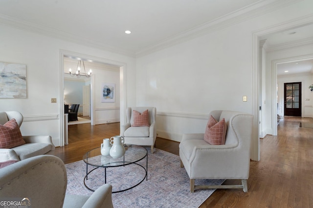 living room featuring ornamental molding, dark wood-type flooring, and a chandelier