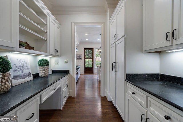 kitchen featuring white cabinets, dark hardwood / wood-style floors, ornamental molding, and dark stone countertops