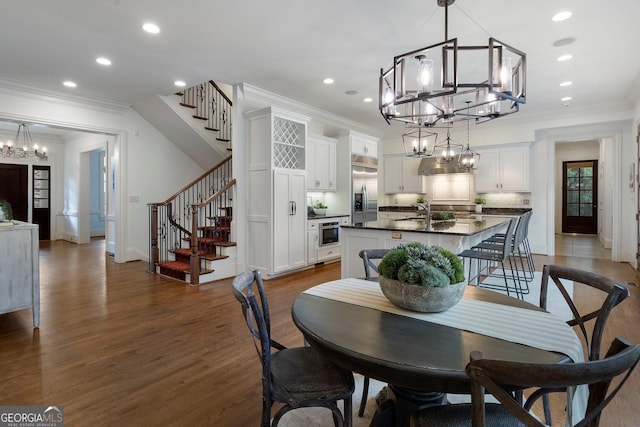 dining area with crown molding, sink, and dark wood-type flooring