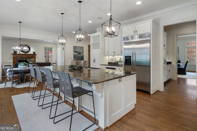 kitchen featuring white cabinetry, pendant lighting, a large island, and stainless steel built in refrigerator