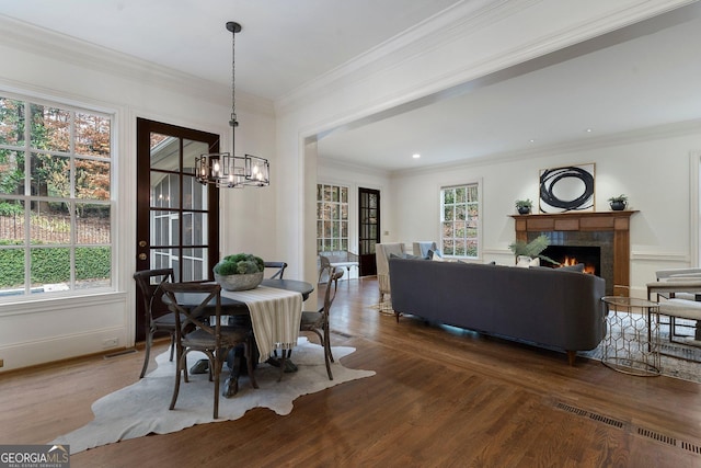 dining room featuring dark hardwood / wood-style floors, ornamental molding, and a chandelier