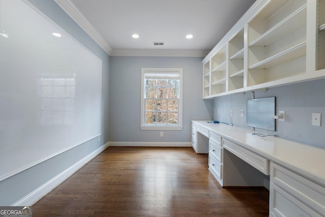 unfurnished office with dark wood-type flooring, built in desk, and ornamental molding