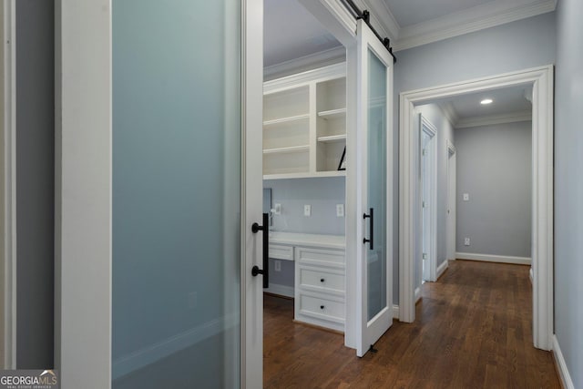 corridor with a barn door, crown molding, and dark wood-type flooring