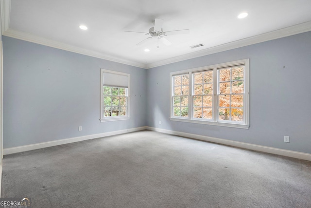 carpeted spare room with a wealth of natural light, ceiling fan, and ornamental molding