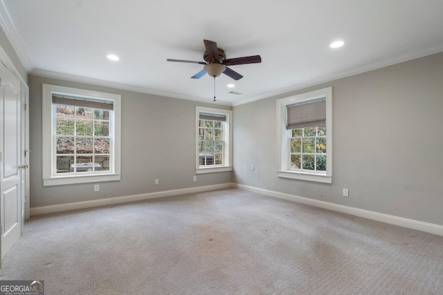 carpeted spare room with ceiling fan, a healthy amount of sunlight, and crown molding