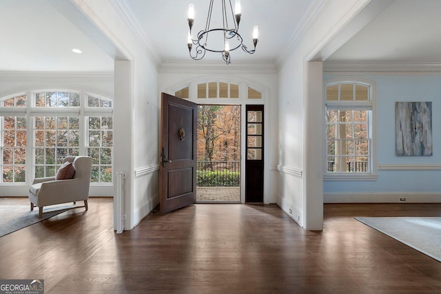 foyer entrance featuring crown molding, dark hardwood / wood-style floors, and an inviting chandelier