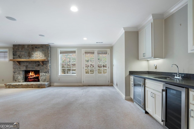 kitchen with white cabinetry, sink, and wine cooler