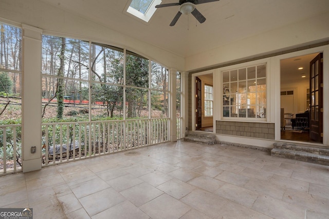 unfurnished sunroom featuring ceiling fan and vaulted ceiling with skylight