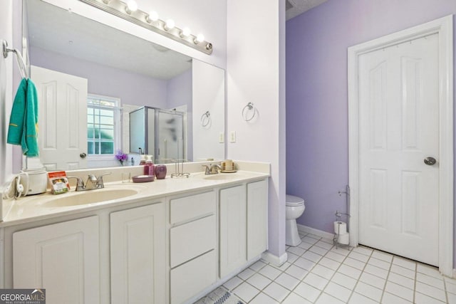 bathroom with tile patterned flooring, vanity, toilet, and a shower with door