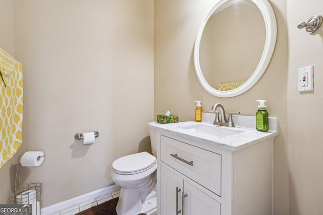 bathroom with toilet, vanity, and tile patterned flooring