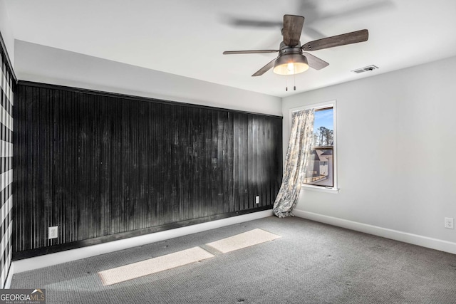 carpeted spare room featuring ceiling fan