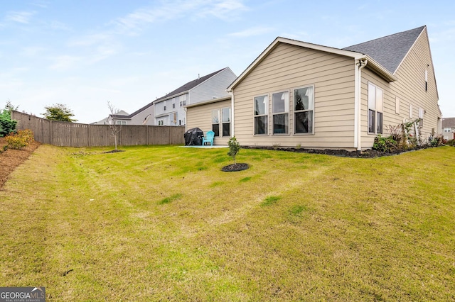 rear view of house featuring a yard