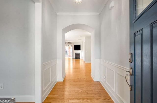 hallway with crown molding and light hardwood / wood-style floors