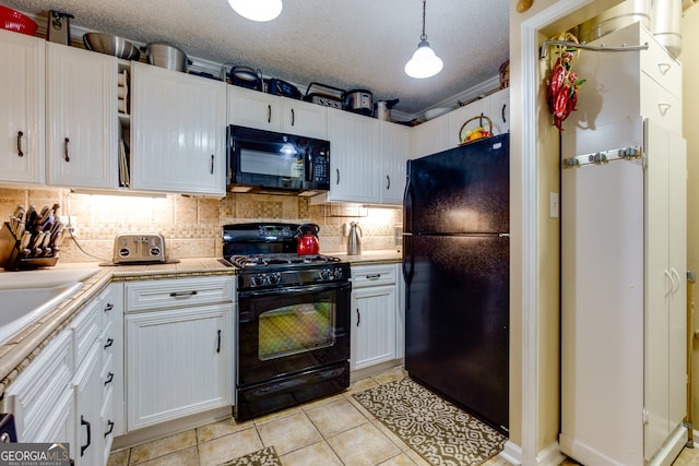 kitchen featuring white cabinets, black appliances, and hanging light fixtures