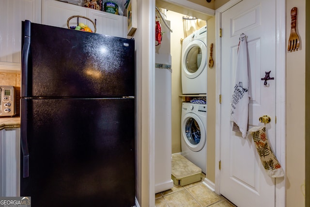 laundry area with light tile patterned floors and stacked washer / drying machine