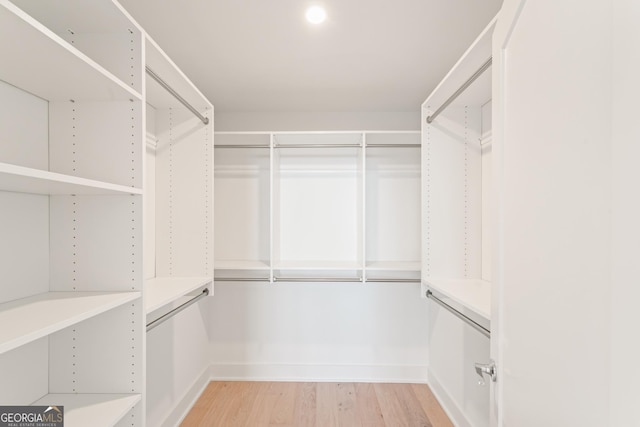 walk in closet with light wood-style floors