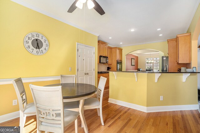 dining area featuring ornamental molding, ceiling fan, and light hardwood / wood-style floors