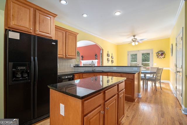 kitchen featuring ornamental molding, black appliances, sink, and a center island