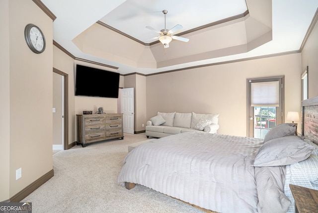 bedroom with ceiling fan, ornamental molding, light carpet, and a tray ceiling