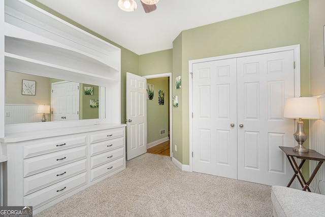 bedroom with a closet, light carpet, and ceiling fan