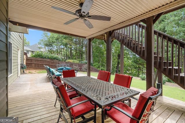 wooden terrace featuring ceiling fan and a yard