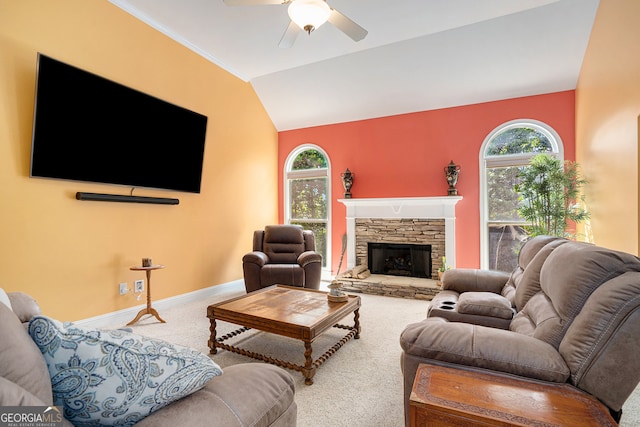 carpeted living room with ceiling fan, a stone fireplace, and lofted ceiling