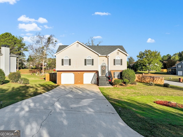 raised ranch with a front lawn and a garage