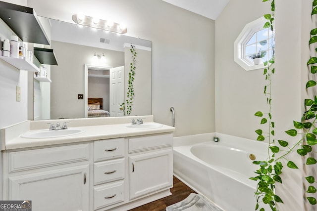 bathroom with hardwood / wood-style floors, vanity, and a bathtub