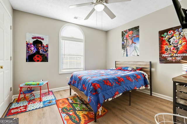 bedroom featuring ceiling fan, a textured ceiling, and hardwood / wood-style flooring