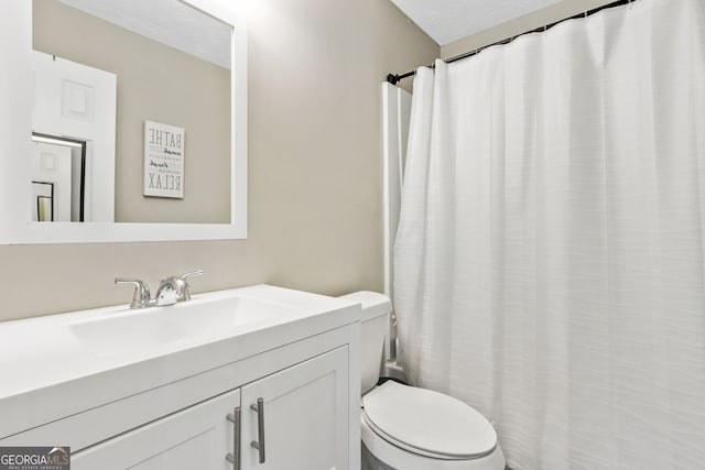 bathroom with curtained shower, vanity, a textured ceiling, and toilet