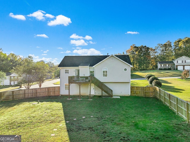 rear view of house with a wooden deck and a lawn