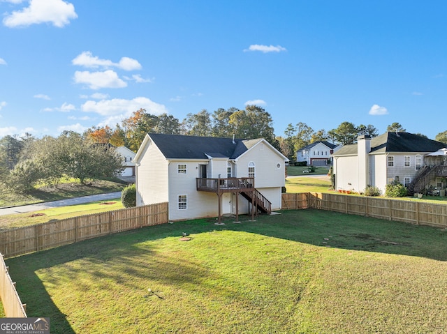 rear view of house featuring a lawn and a wooden deck