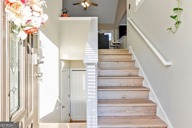 stairway featuring ceiling fan