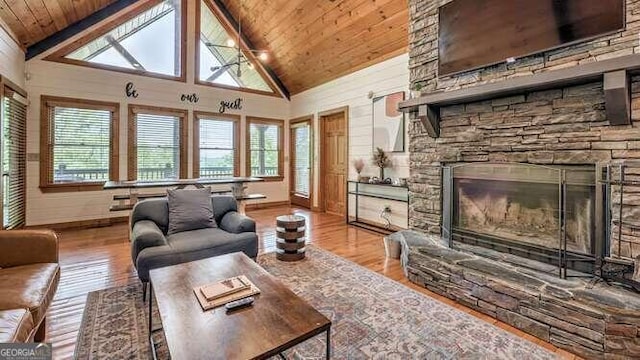 living room with wooden ceiling, hardwood / wood-style flooring, a fireplace, and high vaulted ceiling