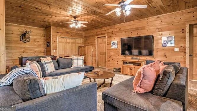 living room with wooden walls, wood ceiling, carpet, and ceiling fan