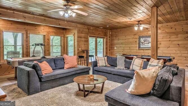 living room with wood walls, hardwood / wood-style flooring, ceiling fan, and wood ceiling