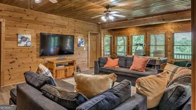 living room featuring light wood-type flooring, wooden walls, wooden ceiling, and ceiling fan