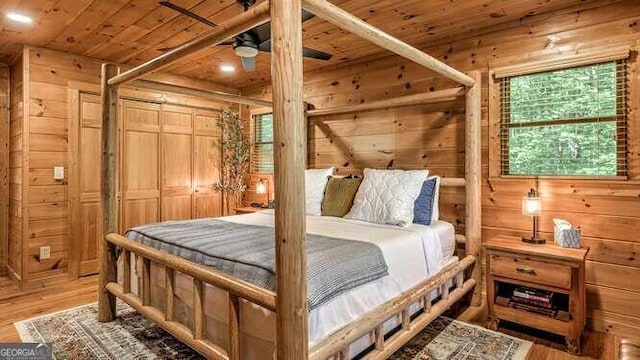 bedroom featuring wood walls, hardwood / wood-style flooring, and wooden ceiling