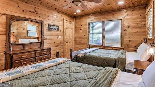 bedroom featuring wooden walls, multiple windows, and wood ceiling