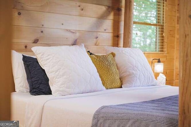 bedroom featuring wood walls