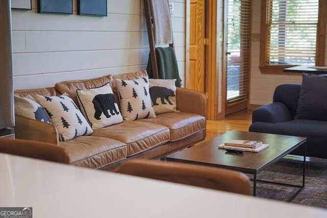 living room featuring hardwood / wood-style floors and wooden walls