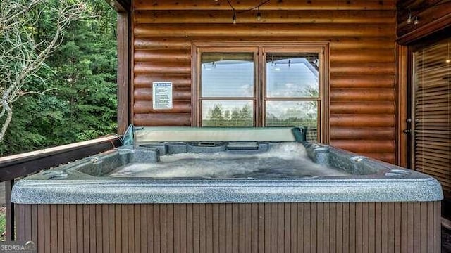 miscellaneous room featuring a hot tub and log walls