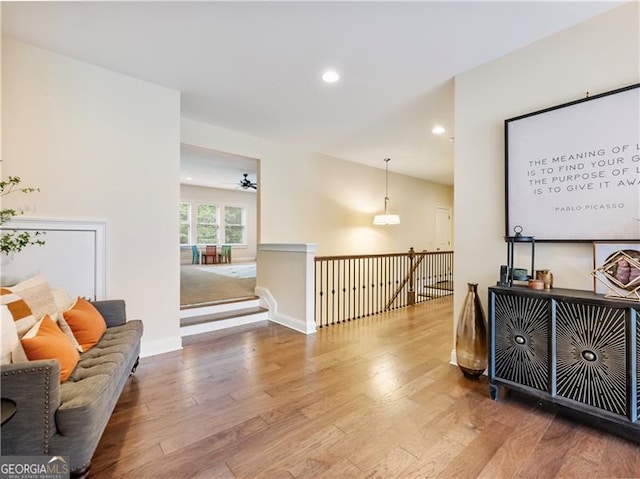 interior space featuring recessed lighting, baseboards, wood finished floors, and an upstairs landing