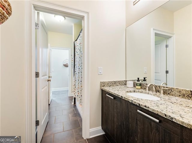 full bath featuring tile patterned floors, vanity, and baseboards