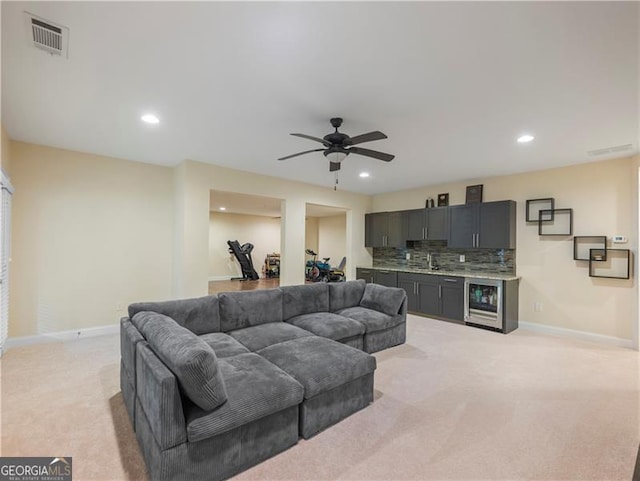 living room featuring light colored carpet, visible vents, baseboards, and recessed lighting