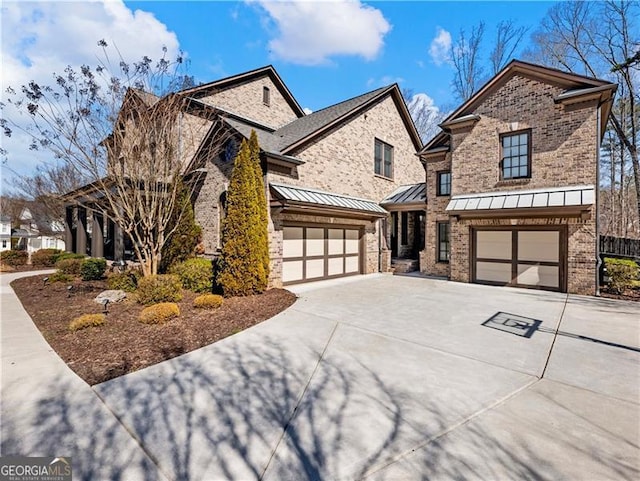 view of front facade featuring a garage, a standing seam roof, concrete driveway, and brick siding