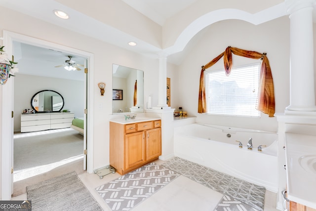 bathroom featuring vanity, decorative columns, and a bath