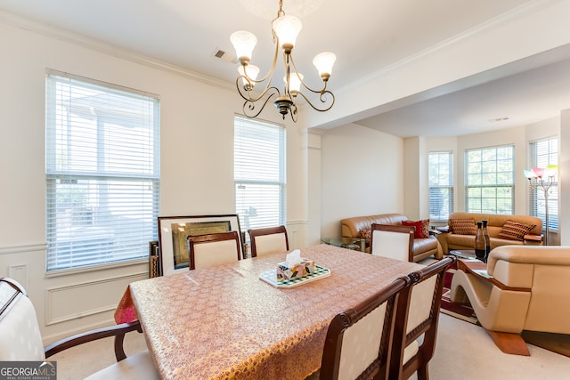 dining area with an inviting chandelier, light colored carpet, ornamental molding, and plenty of natural light