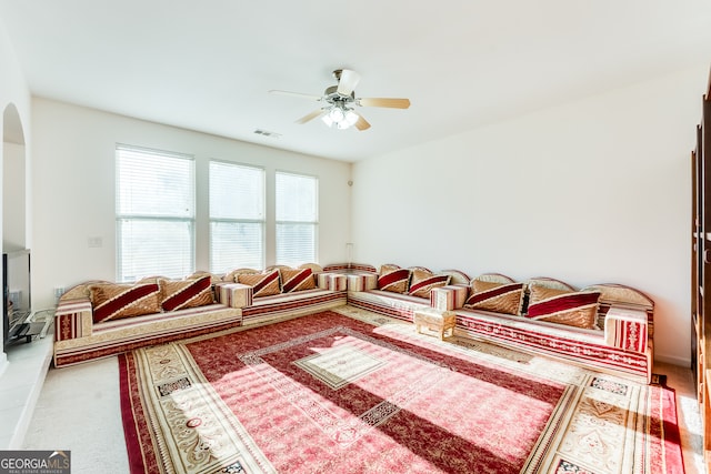 carpeted living room with ceiling fan