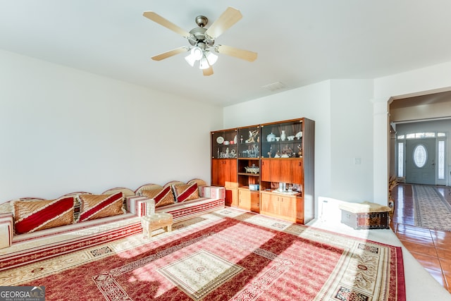 interior space featuring ornate columns, tile patterned flooring, and ceiling fan